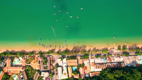 Aerial top view over city and sandy beach with turquoise water alt