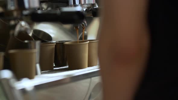 Close Up Shoot of Barista Making Coffee Pouring From Espresso Machine Into Two Paper Cups in Slow
