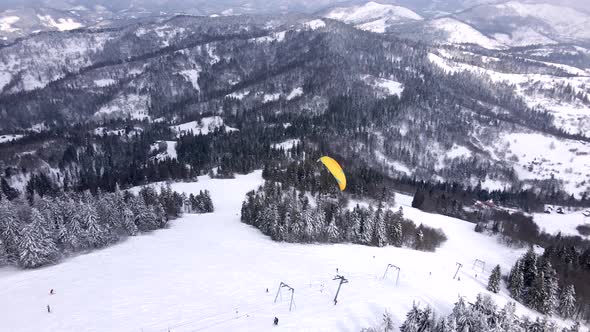 Skier Paragliding Above Ski Resort alt