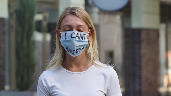 Close Dramatic Outdoors Portrait of a Young White Woman in a Medical Mask with the Inscription I alt