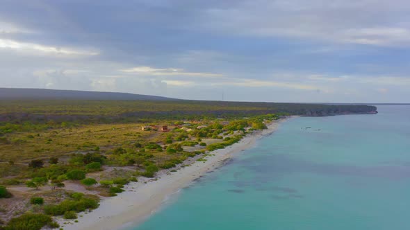 Aerial shot of idyllic landscape with sandy beach and tranquil Caribbean Sea during mystic cloudscap alt