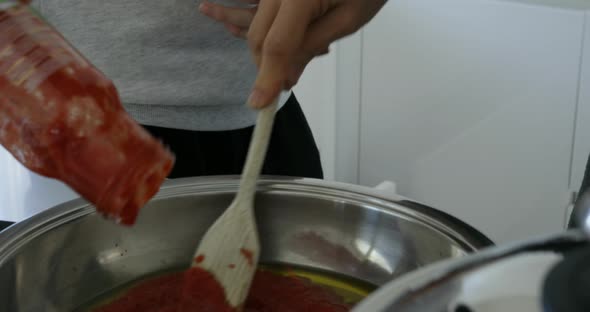 woman preparing spaghetti sauce in a modern Italian kitchen