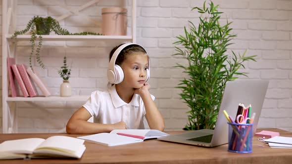 Little Child Girl Using Laptop for Doing School Tasks at Home and Writing Notes