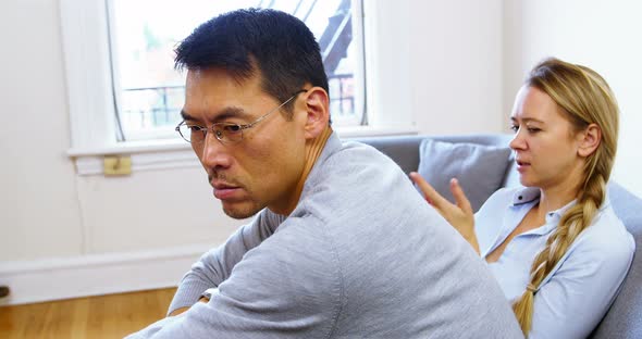 Man and woman upset with each other in living room alt