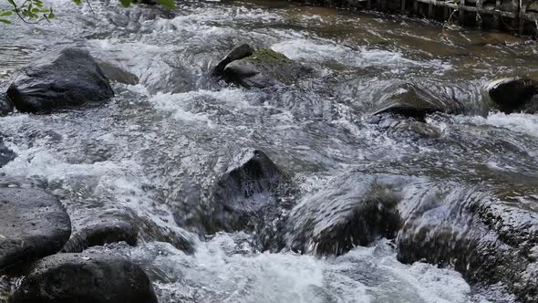 a Mountain River with a Fast Flow of Water and a Rocky Bottom Rages and Flows Slowly alt