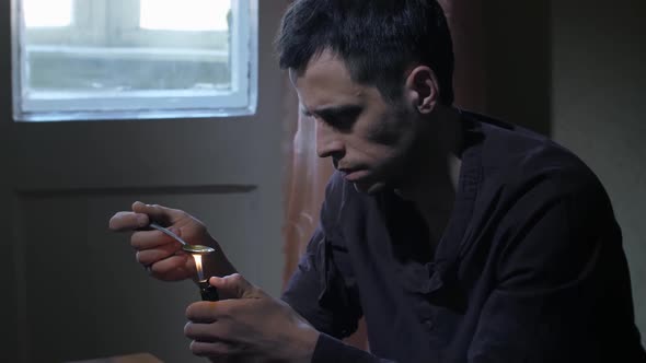 Man Heating Heroin Dose in Spoon with Lighter alt