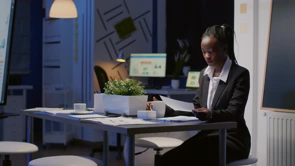 African American Businesswoman Sitting at Conference Table Drinking Coffee alt