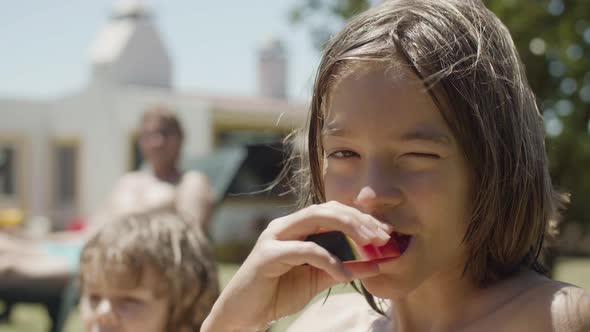 Happy Boy Eating Sweet Watermelon Outdoor and Looking at Camera alt