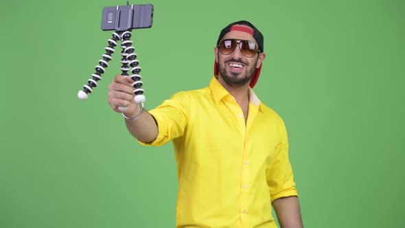 Young Happy Bearded Indian Businessman Vlogging with Phone