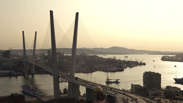 Cable-stayed Automobile Bridge on Which a Lot of Cars Are Traveling Stands Over the Strait on Which