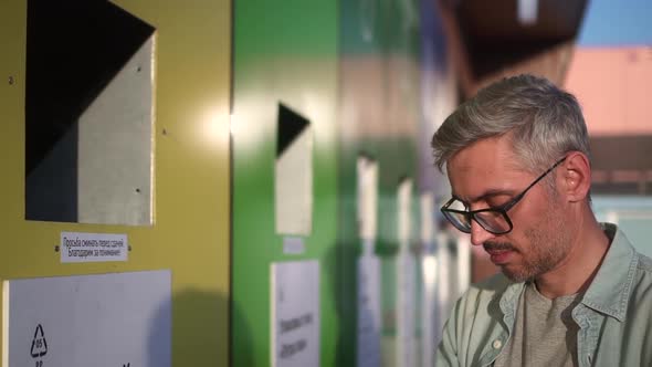 Man Recycles Plastic Waste and Takes Care of Environment Stands Outside on Summer Spbd alt