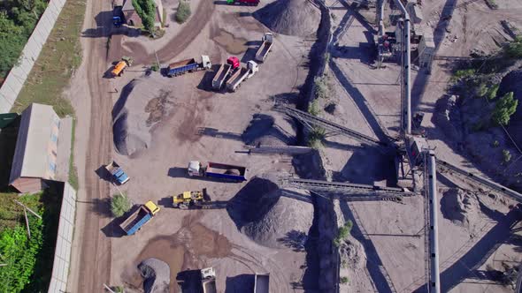 Excavator Loading Crushed Stone Into a Dump Truck in a Crushed Stone Quarry alt