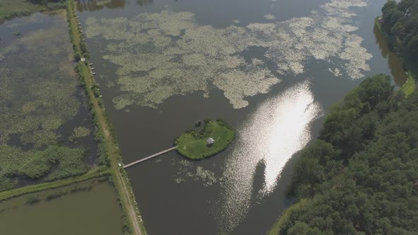 Aerial of a pond with a small island alt