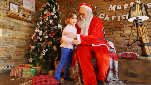  Little Girl Hugs  Santa and Smiles Happily.