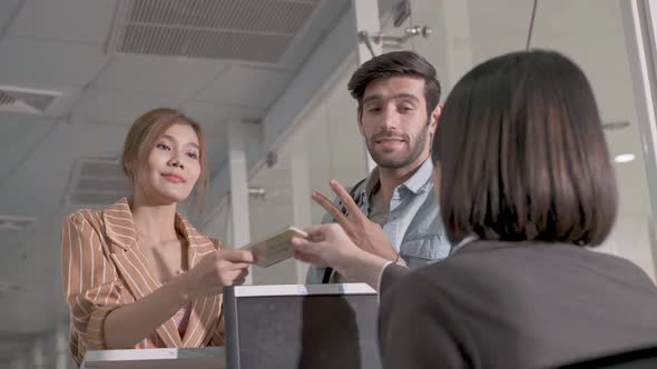Couple tourist talking to staff at airline check in counter service alt