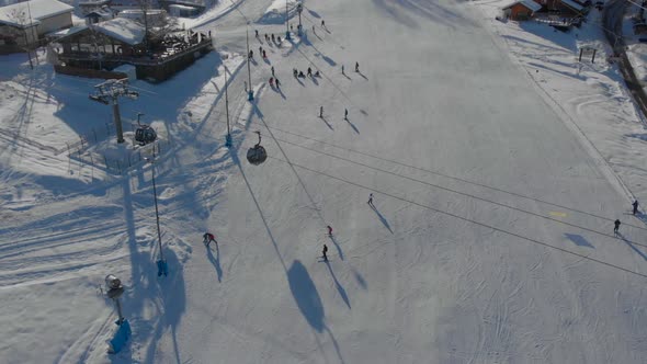 Slope of Ski Resort with Trail for Skiing and Snowboarding Moving Cable Cars Aerial View alt