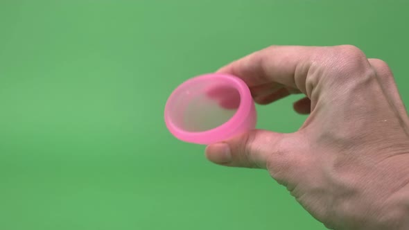 Pink Menstrual Cup Closeup on Green Background