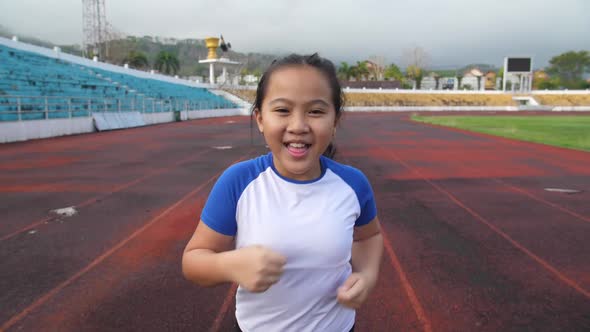 Front View Of Little Girl Running At Stadium alt