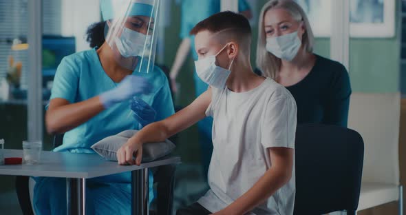 Women and Boy During Painful Vaccination in Clinic alt