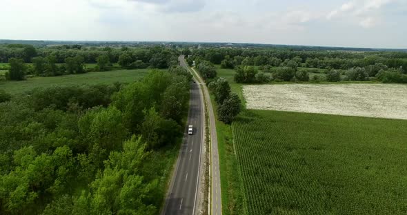 Cars on Road with Farming Landscape  alt