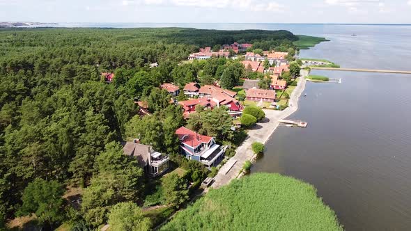 Small luxury coastal town of Pervalka in Neringa region, Lithuania. Aerial fly over view alt