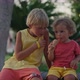 Little Brother Share Ice Cream with Elder Brother at a Park - VideoHive Item for Sale