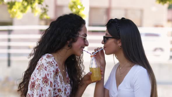 Happy Multiethic Hipster Teenage Friends Drinking Orange Juice in City