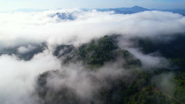 An aerial view from a drone flying over the many fogs in the mountains alt