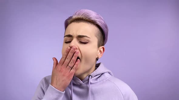 Cool Stylish Young Adult Woman Yawning Shuddering on Purple Background alt