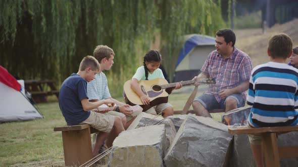 Kids at summer camp around campfire