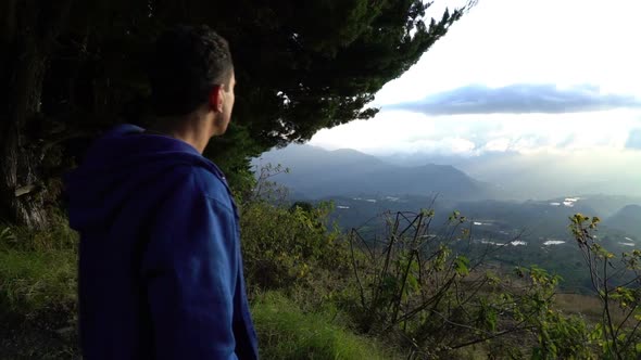 Man Standing on the Edge of Mountains and Looking Around