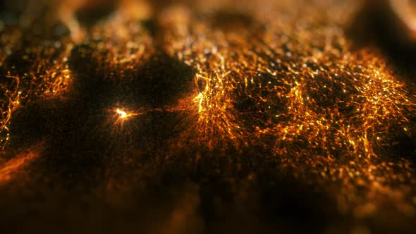 Gold particles floating in liquid on black background.
