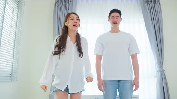 Asian attractive loving couple enjoy dance together in bedroom at home. alt
