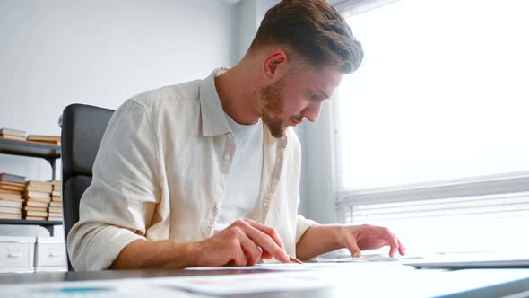 Bearded corporate financial director checks paper reports alt