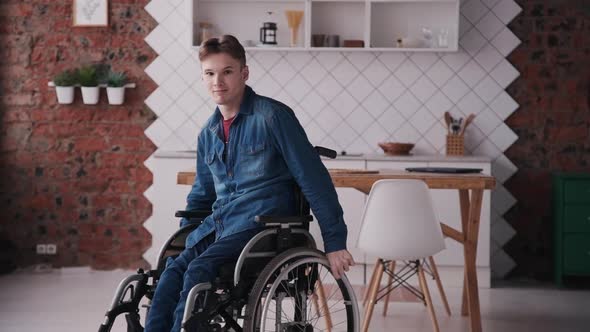 Young Man in Wheelchair Looking at Camera. Concept Posing, Chair. Portrait of Invalid Male