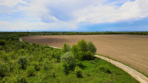 Aerial View of Plowed Agricultural Field Prepared for Planting Crops in Spring alt