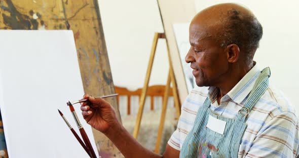 Confident artist holding paintbrush alt