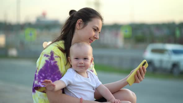 Toddler with Mom Relaxing on the Street in the City alt