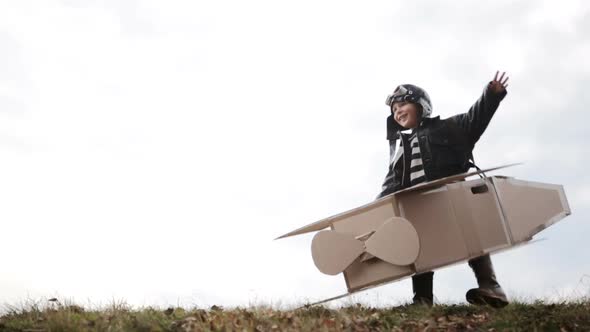 Young Pilot or Aviator Boy Plays and Smile with His Carboard Airplane