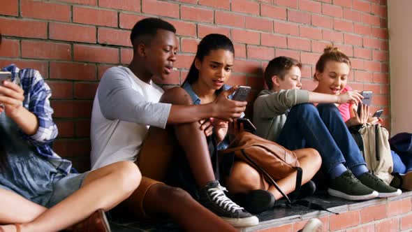 Group of school friends using mobile phone 4k alt