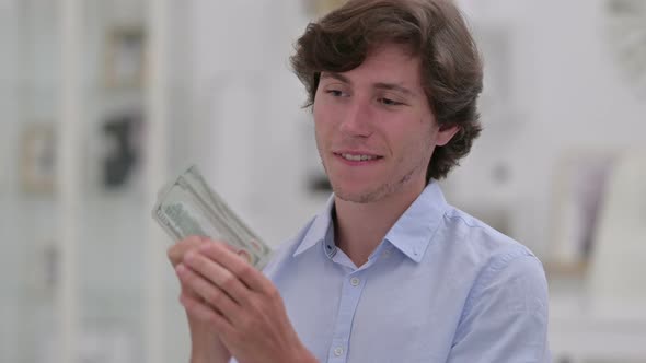 Successful Casual Young Man Counting Dollars  alt