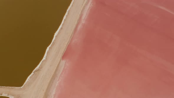 High Angle View of Dirt Road Leading Between Two Colourful Lakes alt