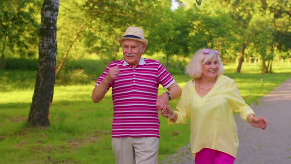 Happy Senior Stylish Couple Family Grandmother Grandfather Enjoying Date Dancing in Summer Park alt