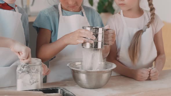 Unrecognizable Children Adding Flour to Bowl alt