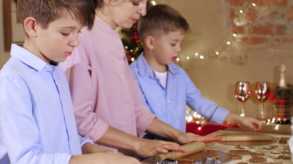 Children with Mother is Forming a Dough with for Bakes a Cookies at Christmas
