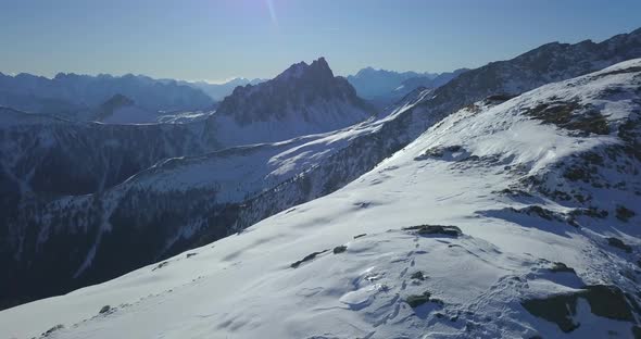 Aerial drone view of snow covered mountains in the winter. alt