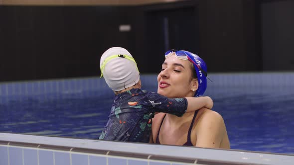 Young Woman Instructor with a Little Kid in the Swimming Pool alt