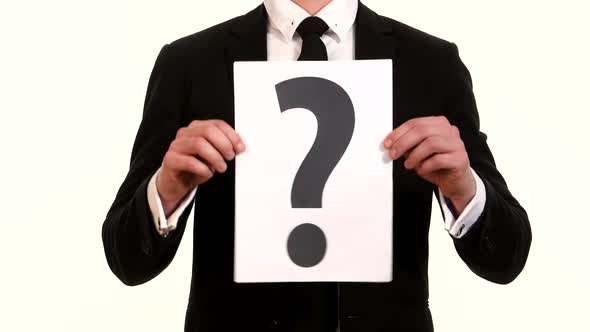 Man in a Suit Holding a Sign Question Mark alt