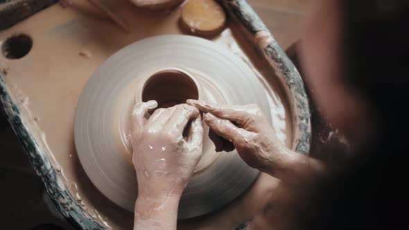 Man Potter Working on Potters Wheel Making Ceramic Pot From Clay in Pottery Workshop alt