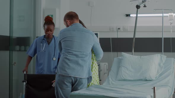 African American Nurse Helping Pregnant Woman in Wheelchair alt